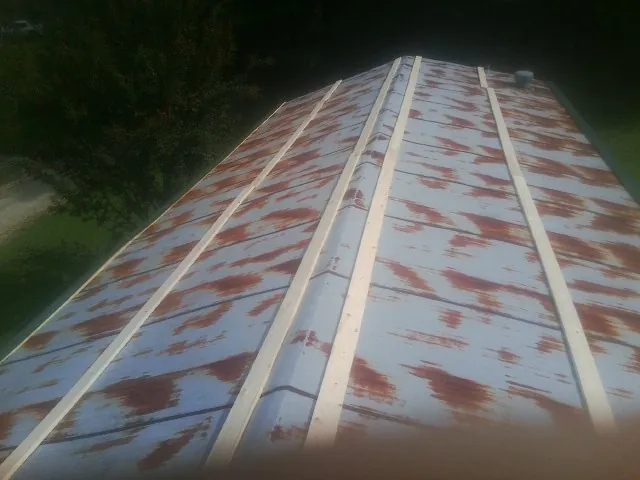 Rusted metal roof panels with new wood purlins before replacement — Storm Damage Roof Repair in Nettleton by Roofing Brothers