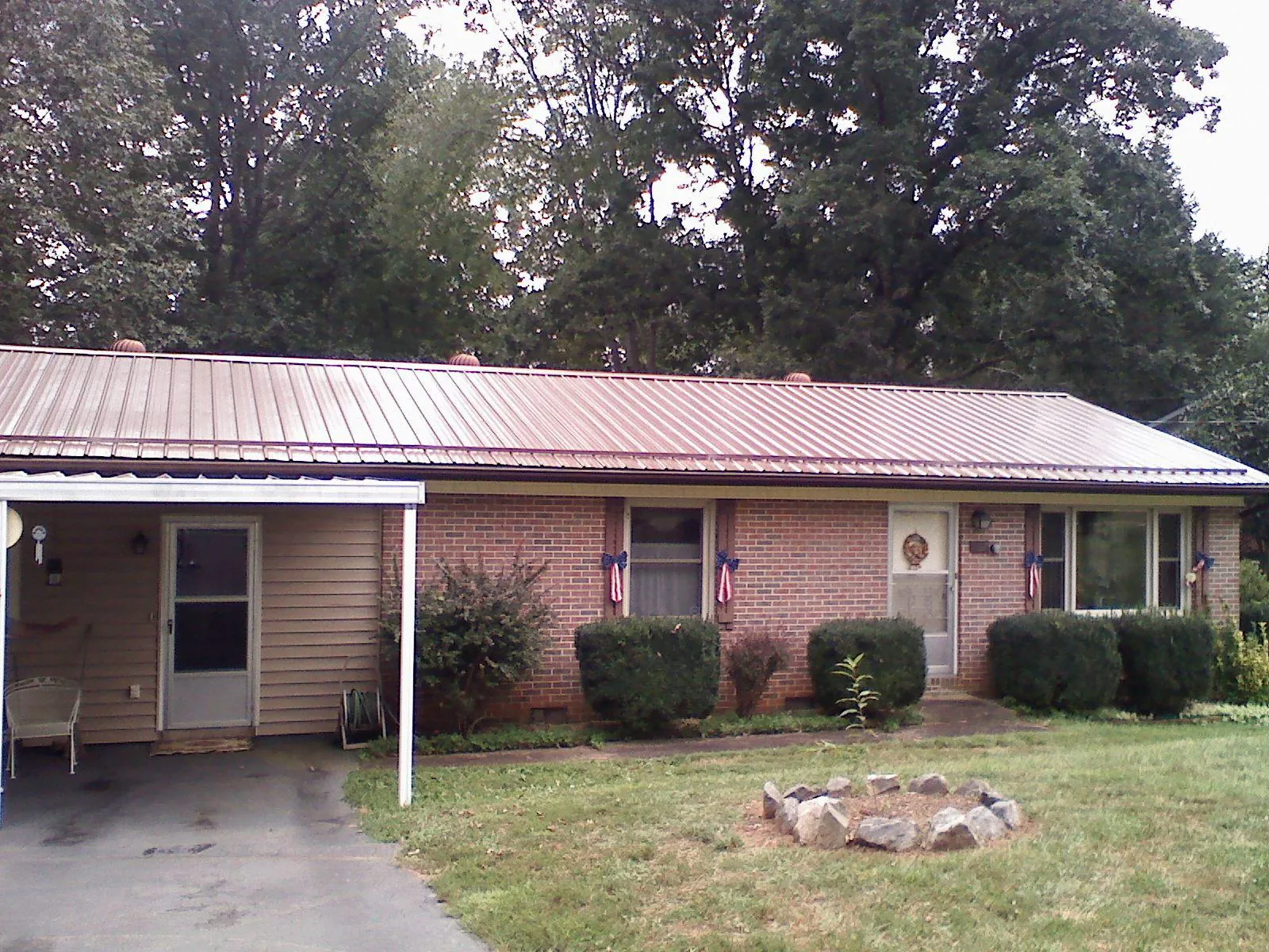Bronze metal roof and carport on a brick ranch home — Roof Repair work by our crew in Nettleton